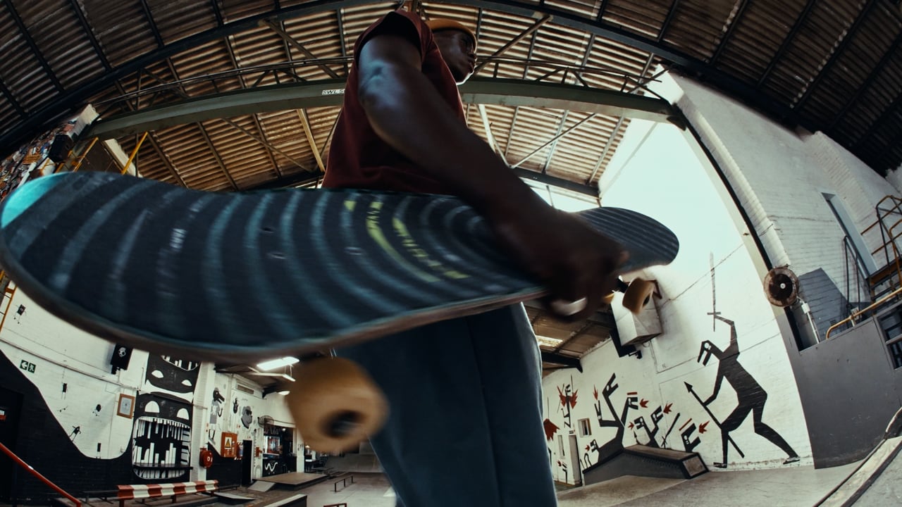 Skateboarder holding a board in an indoor skate park